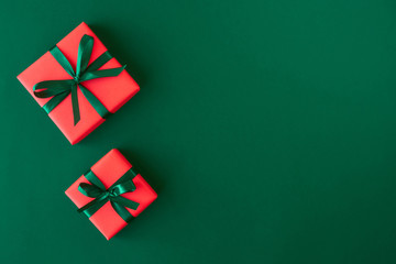 Red gift boxes on green background. Christmas card. Flat lay. Top view with space for text