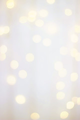 Blurred wooden white background with warm bokeh lights. Wooden background with yellow bokeh bulbs. Selective focus.
