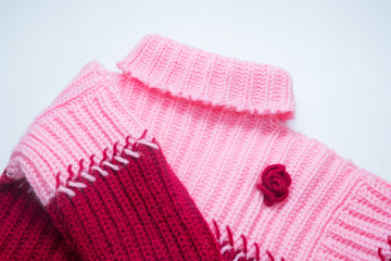 women's knitted woolen pink with a burgundy sweater on a white table