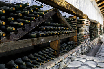 Stacked of old bottles in the cellar