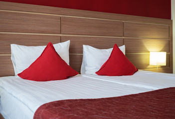 Beautiful bed with red pillows in the room