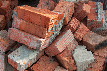 Background of red brick. Old red brick at a construction site. Old brick unsuitable for...