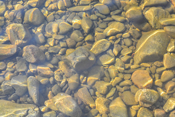 Background of shiny pebbles on the river bottom.