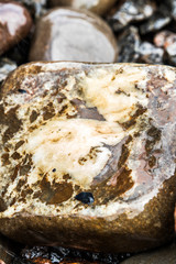 Wet, round stones lie at the bottom of the fountain. Round, big wet pebbles. Stone texture.