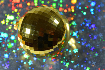 Gold reflective Christmas bauble with colorful Christmas themed bokeh background