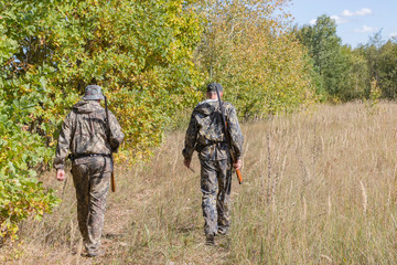 Hunters men with weapons go hunting