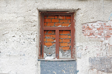 An old concrete wall with bricked up window