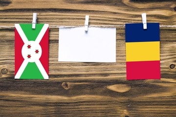 Hanging flags of Burundi and Chad attached to rope with clothes pins with copy space on white note...