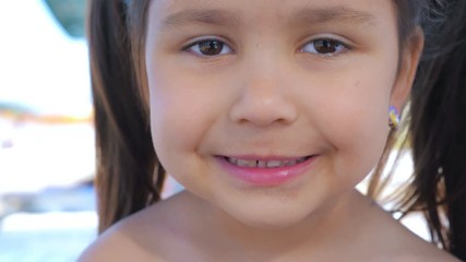 Portrait of a little cute toothless smiling girl. Close up.