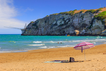 The most beautiful beaches of Apulia: Zaiana Bay, enclosed by two rocks, stretches a few kilometres away from Peschici in Gargano, Italy. In the background a characteristic trabucco (or trebuchet).