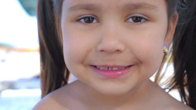 Portrait of a little cute toothless smiling girl. Close up.