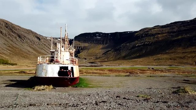 Aerial, orbit drone shot, panning around a old shipwreck, the Gardar BA64, in West fjords, Iceland