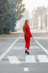 beautiful girl with red hair dressed in a red business suit. Business portrait.