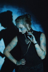 blue portrait of a beautiful young girl with a shadow pattern on the face and background from the projector