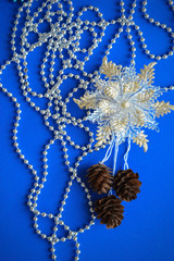 Christmas card blue, merry Christmas and New year. Gray beads, Christmas ball, beautiful toy and fir cones for decoration. Decor for the holiday. Gray Christmas ball. Beautiful decorations for the Chr
