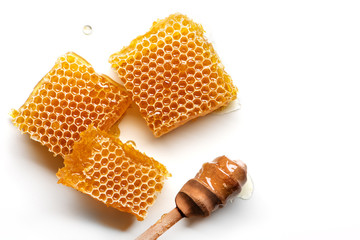 Honeycomb with honey spoon isolated on white background.