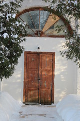 snow covered entrance through an old wooden door