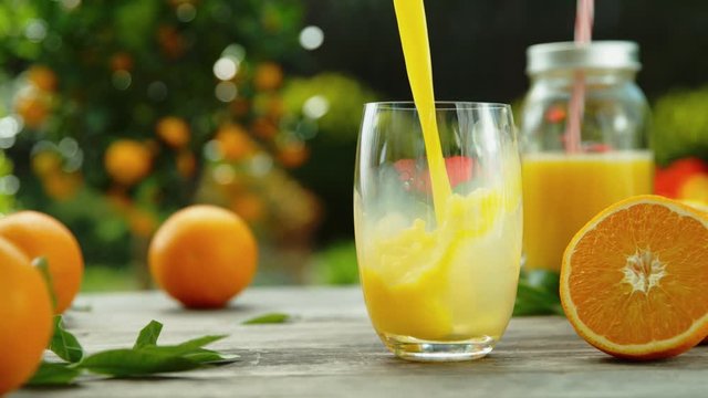 Super slow motion of pouring orange juice into glass, speed ramping effect. Filmed on high speed cinema camera, 1000 fps.