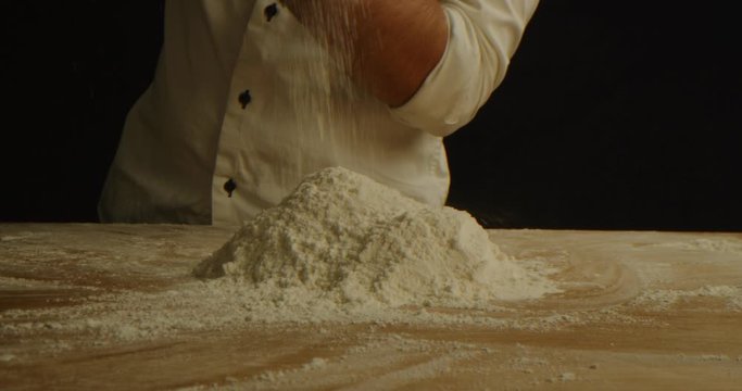 Saturating flour with air, kneading dough for pizza close up, chef makes dough, red epic, slow motion, cooking process 