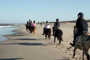 Gruppe von Reitern am Strand