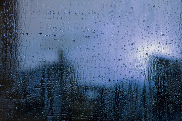 Rain drops on window with view of dark street