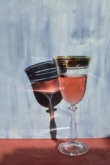 rose wine in a glass on a cantaloupe table and a shadow from the glass