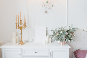 Christmas decor white chest of drawers in the bedroom or living room, candlestick, spruce arrangement and candles