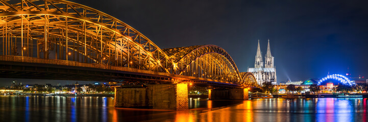 The Hohenzollern Bridge over the Rhine River and Cologne Cathedral by night