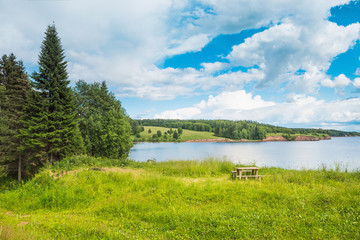 Obraz premium Beautiful panoramic view of the Kama river from the hill in the foreground green grass, summer blue sky with clouds.
