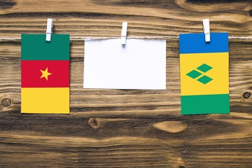 Hanging flags of Cameroon and Saint Vincent And The Grenadines attached to rope with clothes pins...