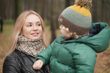 Fototapeta premium caucasian young mother and little child having fun in autumn Park, walking