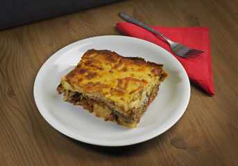 Moussaka. A Greek traditional dish on a wooden table 