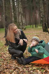 a beautiful Caucasian mother and little child having fun in autumn Park, walking with umbrella