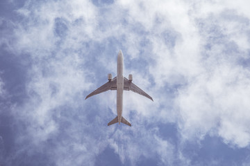 Airplane on blue sky with clouds. Travel around the world in the air