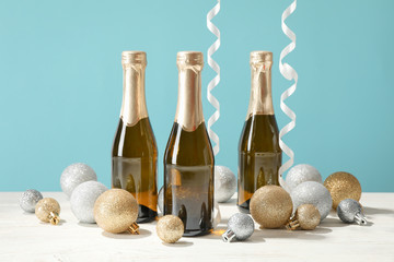 Baubles and champagne mini bottles against blue background, space for text