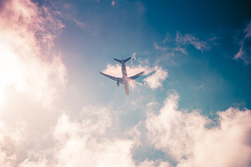 Airplane on blue sky with clouds. Travel around the world in the air