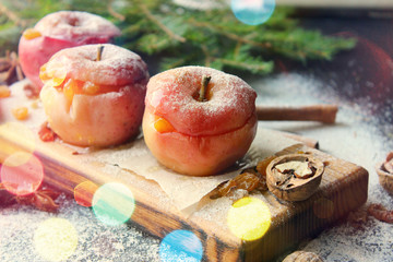 Baked apples with nuts, honey and cinnamon on a wooden background.New year, Christmas background, festive dessert. Tinted effect, copy space.