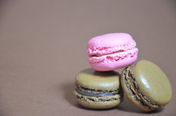 Colourful tasty macaroons in a row. macaroons of different colors on a brown background