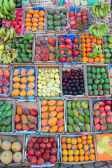 Fruit trays for sale of mangoes, pomegranates, bananas, plums, guava, oranges