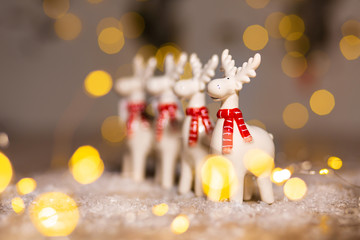 Decorative Christmas-themed figurines. Christmas deer. Christmas tree decoration. Festive decor, warm bokeh lights.