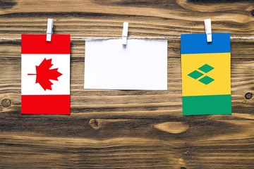 Hanging flags of Canada and Saint Vincent And The Grenadines attached to rope with clothes pins...