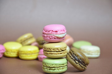 Colourful tasty macaroons in a row. macaroons of different colors on a brown background