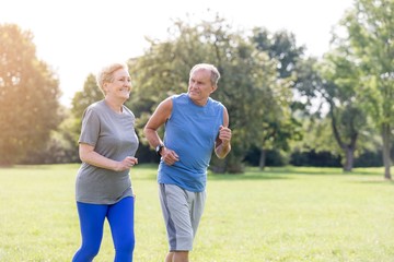 Healthy senior couple jogging in park