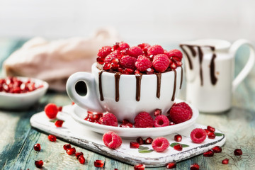 Raspberry mug cake in a red ceramic mug on wooden background