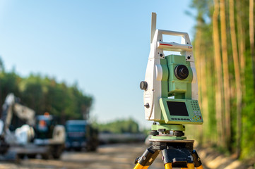 Surveyor engineer with equipment (theodolite or total positioning station) on the construction site...