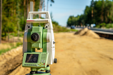 Surveyor engineer with equipment (theodolite or total positioning station) on the construction site...