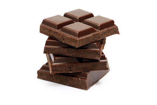 Stack of dark chocolate bar pieces isolated on white background
