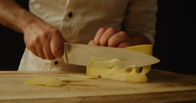 Chef slicing cheese close up, macro shot of cooking process, red epic, dramatic look, slow motion