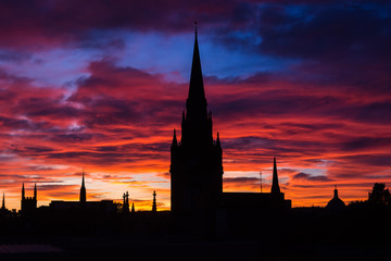 Naklejka premium Silhouette of church and buildings in the city center of Aberdeen in Scotland. Amazing and colorful sunset in Aberdeen. Pink and blue sky. Low light photography.