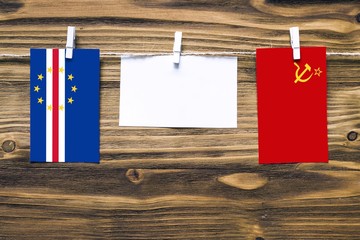 Hanging flags of Cape Verde and Soviet Union attached to rope with clothes pins with copy space on...